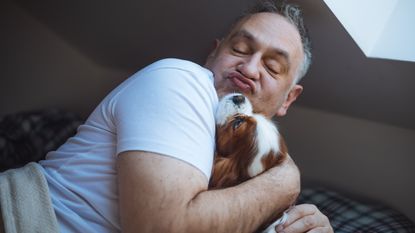 A man cuddles with his dog.