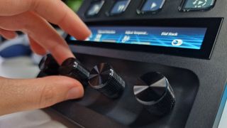 A close-up shot of the Stream Deck + dials and touchscreen with a hand in shot to show the size