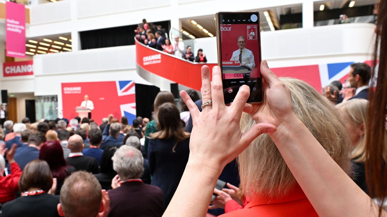 MANCHESTER, ENGLAND - JUNE 13: A woman films on a mobile phone as Labour Party leader Sir Keir Starmer speaks during the launch of Labour&#039;s general election manifesto on June 13, 2024 in Manchester, United Kingdom. Labour is consistently leading the polls by over 20 points, according to the latest YouGov data. (Photo by Anthony Devlin/Getty Images)