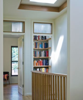 A bookshelf nook on a stair landing with a skylight