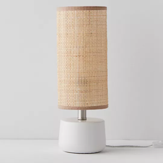 table lamp with stout circular base and tall rattan drum shade