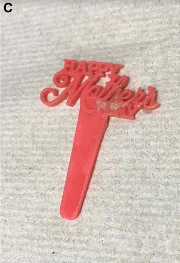 An image of the cupcake topper after it was removed from the man's esophagus. It said "Happy Mother's Day."
