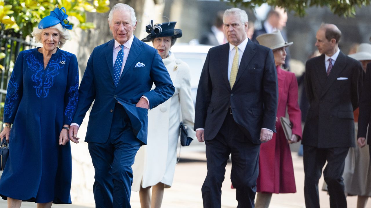 Queen Camilla, The King, Princess Anne, Prince Andrew and the Duke and Duchess of Edinburgh walking outside in suits and dress coats