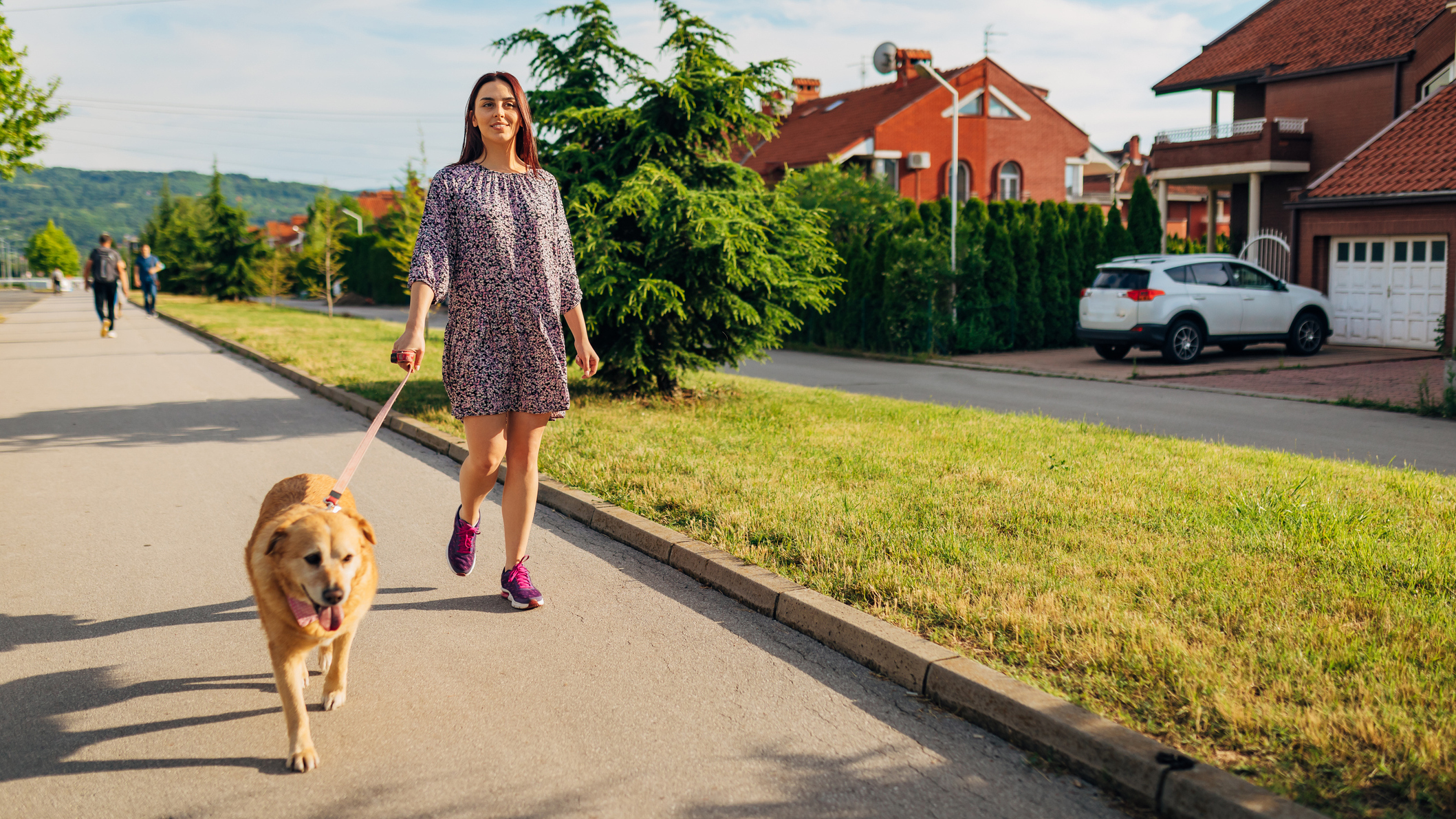Woman walking dog on street