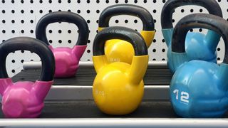 2 rows of brightly coloured kettlebells