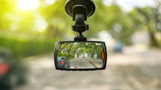 A dash camera attached to a car windscreen