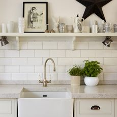 kitchen with white brick designed tiles on wall and wash basin with faucet