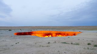 A picture of the gates of hell by day show the near-circular pit glowing orange.