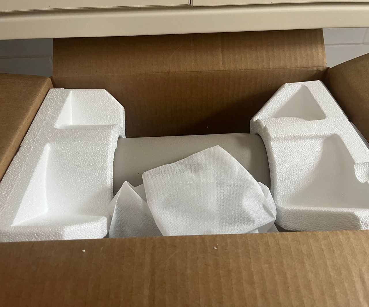 A top view of the styrofoam packaging in the brown KitchenAid Artisan Plus Stand Mixer