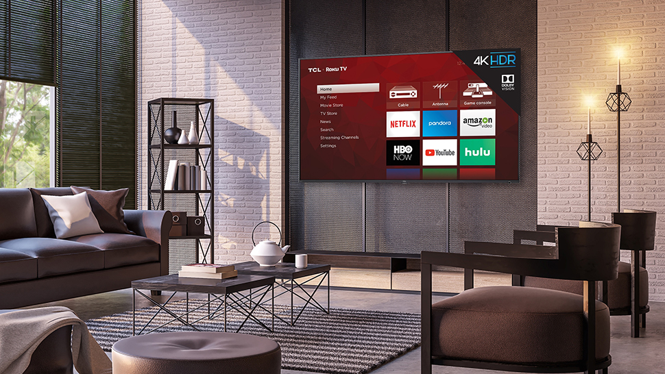 TCL 6-Series wall-mounted in a living room and displaying the TV's OS