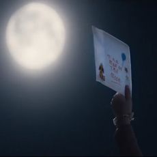holding paper with text at moon