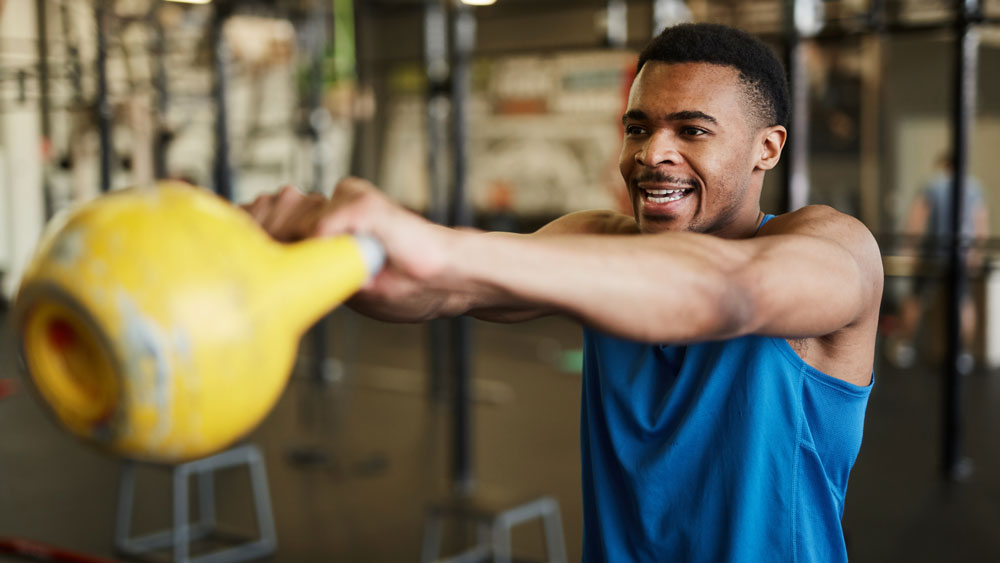 Man performs kettlebell swing exercise
