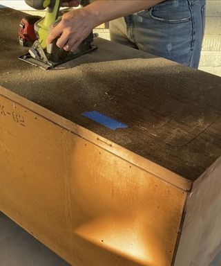 Brooke Waite using a circular saw to cut into dresser vanity