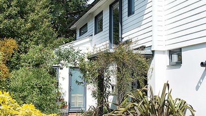 exterior of a modern house with brick and wood clad exterior in Cambridge with porch and shrubs in front garden