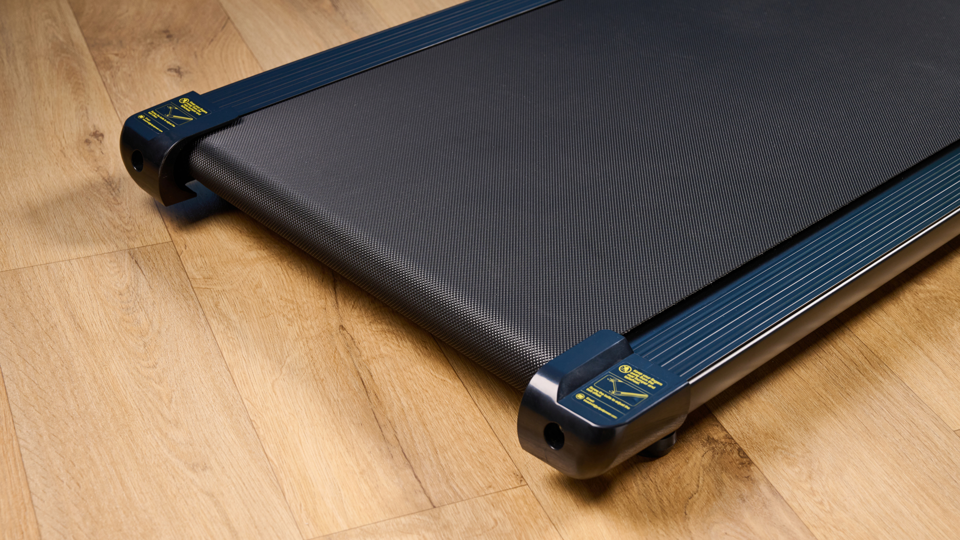 the deerrun q1 mini under desk treadmill walking treadmill in a home office with a blue wall and wooden floor