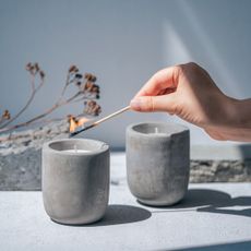 Affordable candles - person lighting a grey candle