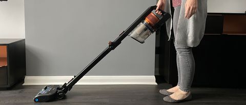 The Shark Anti Hair Wrap Cordless Stick Vacuum Cleaner with PowerFins & Flexology being used to clean hard floor