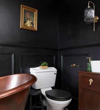 Black bathroom with bath, loo and wooden vanity