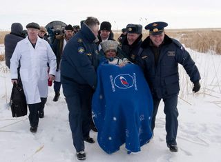 Russian cosmonaut Maxim Suraev, mission engineer, being assisted following the successful landing of the Soyuz spacecraft.