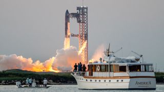 A giant SpaceX Starship lifts off with spectators watching from nearby boats in a bay