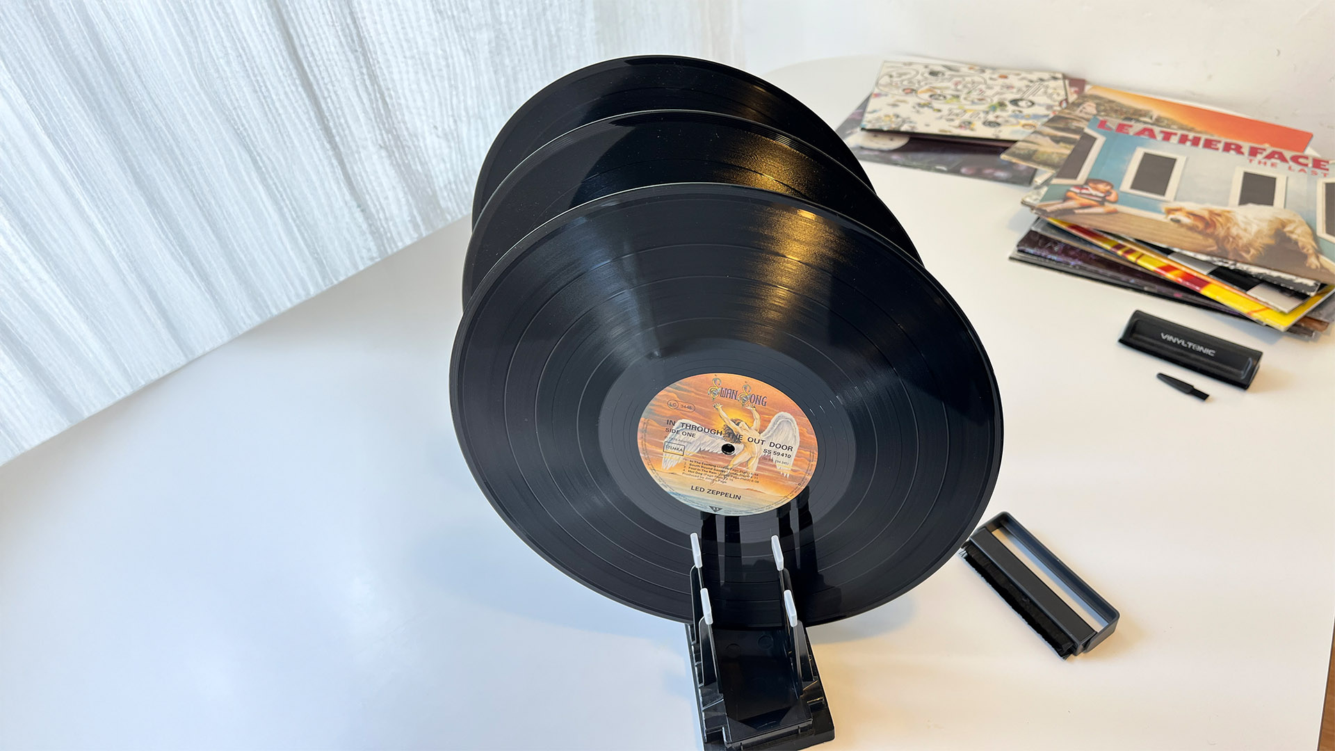 Vinyl records drying in Spincare record rack on white table