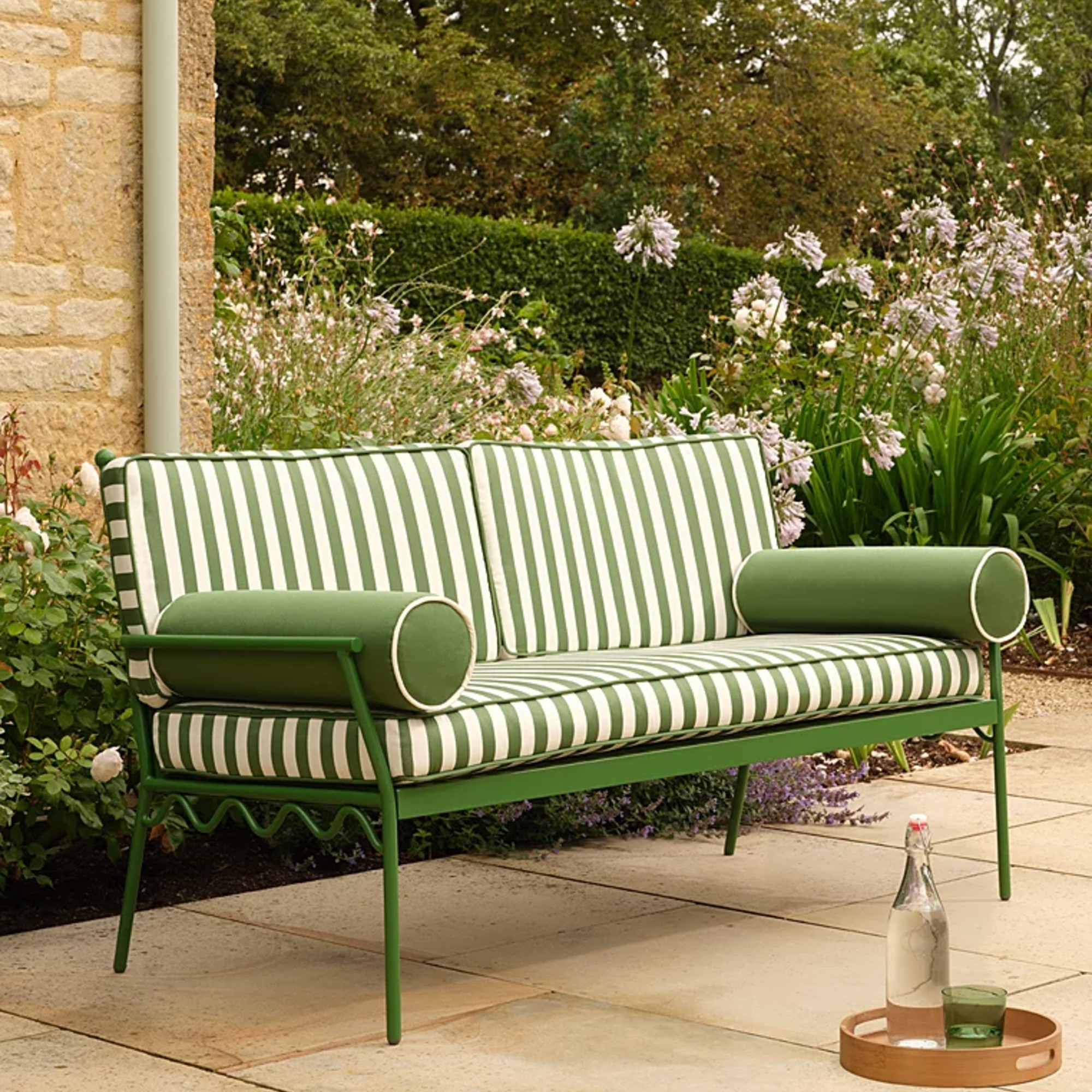 George Home Riviera Green and White Stripe Metal Garden Bench in a garden