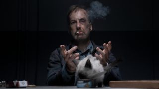 Bob Odenkirk smokes a cigarette in an interrogation with a cat in Nobody.