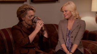 Leslie Knope (Amy Poehler) with her mother on a couch in Parks and Recreation
