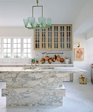 White kitchen with marble island and green pendant