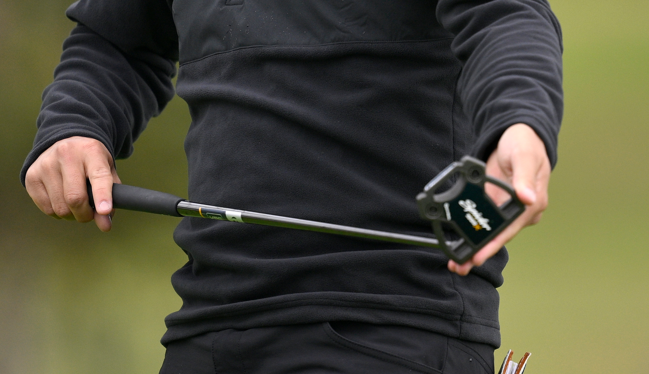 Collin Morikawa wipes his putter face