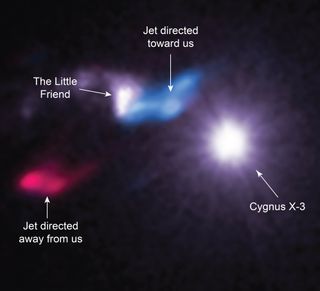 The X-ray binary Cygnus X-3, where a massive star is slowly being eaten by a companion black hole or neutron star, is blasting X-rays toward us and toward the nearby stellar nursery called "Little Friend," which then reflects the rays back to us. Jets of gas (whose carbon monoxide here is shown in red and blue) indicate star formation within Little Friend.