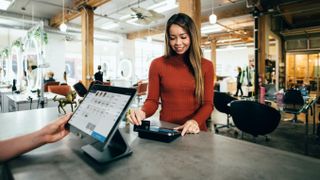 A woman swiping her card on a POS device