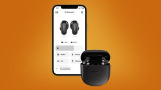 Ett par svarta Bose QuietComfort Earbuds II ligger i sitt laddningsfodral framför en iPhone som visar Bose Music-appen. Visas mot en orange bakgrund.