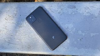 A Google Pixel 5 from the back, on a stone surface