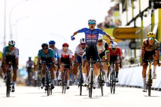 Bike rider called Jasper Philipsen competes in a blue jersey in a bike race