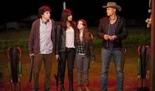 Jesse Eisenberg, Emma Stone, and Abigail Breslin standing outside with Woody Harrelson in Zombieland.