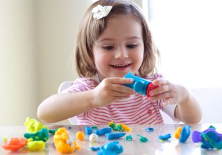 child playing with playdoh