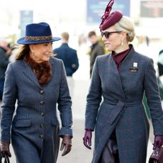 Carole Middleton and Zara Tindall wearing gray coats walking next to each other