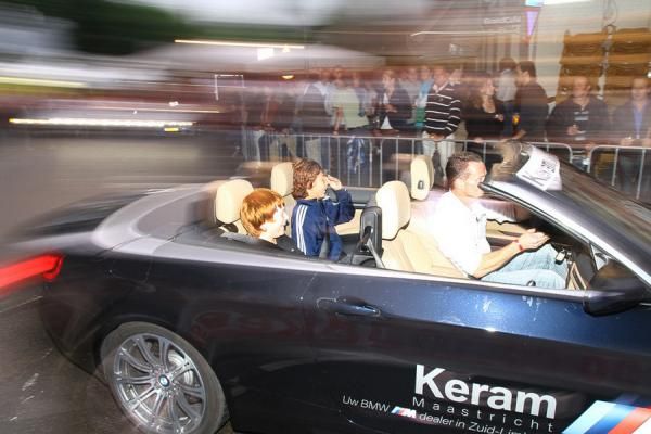 In the race car behind.