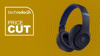 Beats Studio Pro navy wireless bluetooth headphones on yellow background with price cut sign