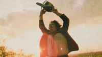 Leatherface holding a chainsaw above his head during the ending of the horror movie, The Texas Chain Saw Massacre 