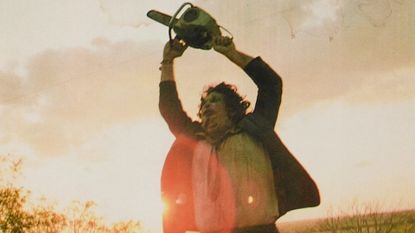 Leatherface holding a chainsaw above his head during the ending of the horror movie, The Texas Chain Saw Massacre 