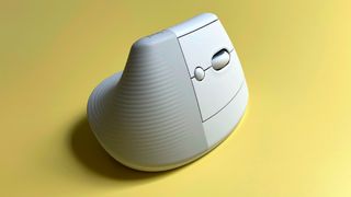 The Logitech Lift for Mac mouse against a yellow background.