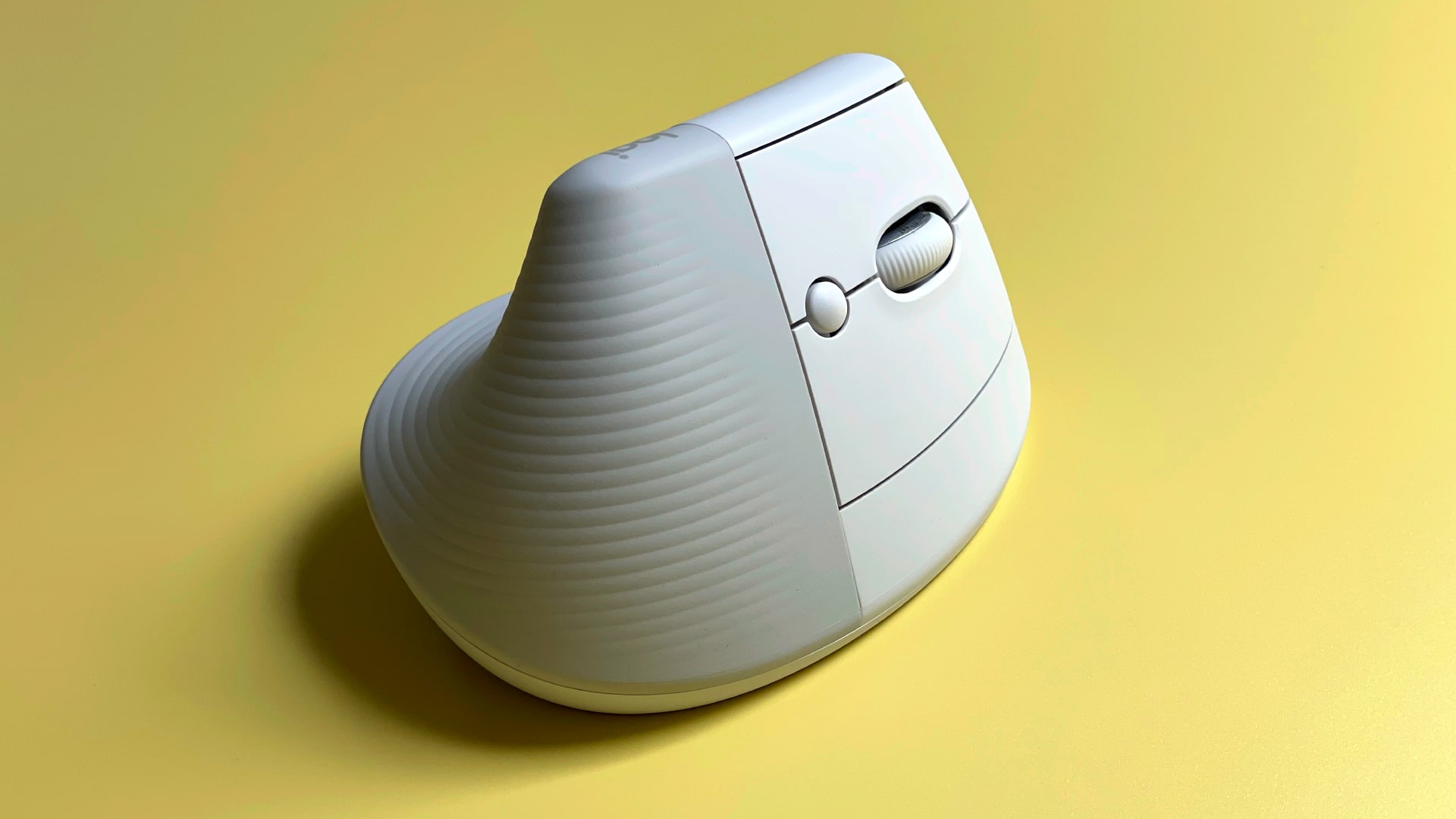 Logitech Lift mouse for Mac on a yellow background.