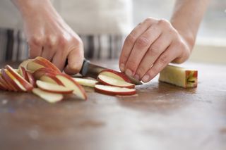 Red apples are sliced on a chopping board