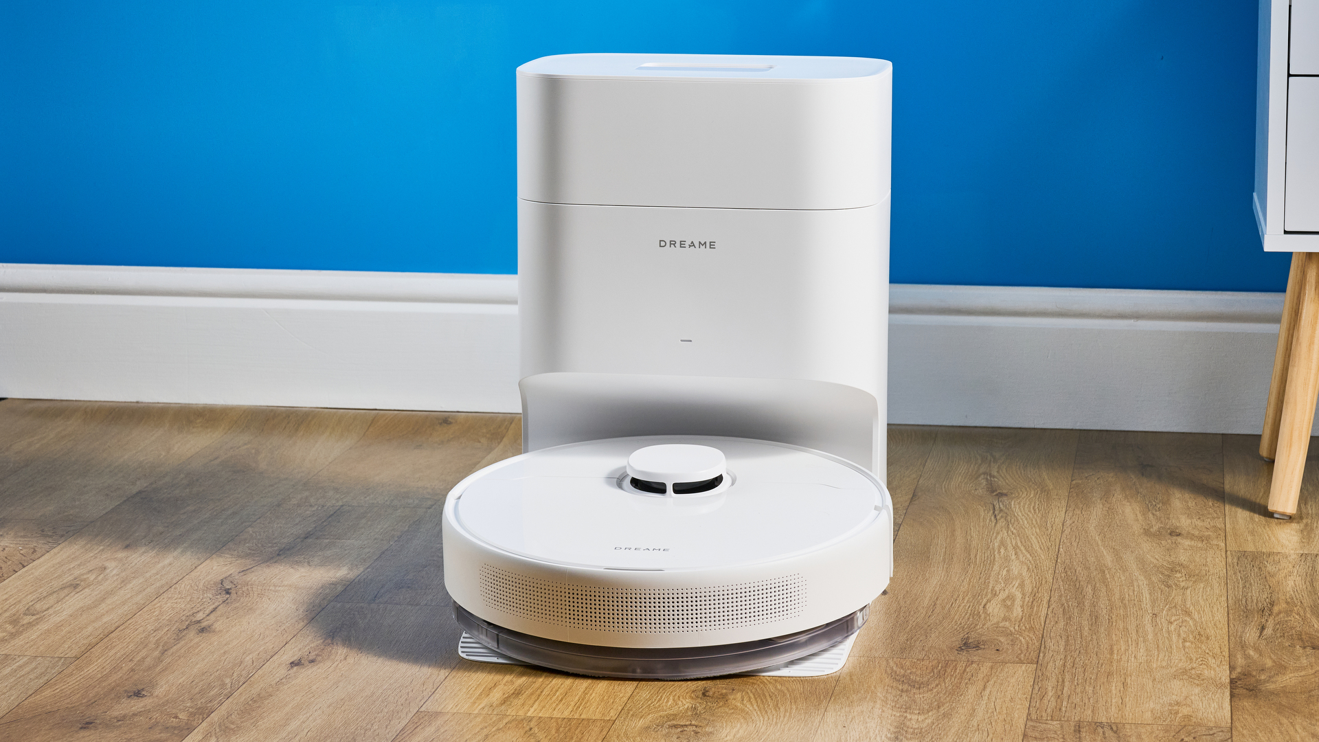 Dreame D10 Plus Gen 2 photographed on a wooden floor in front of a blue backdrop