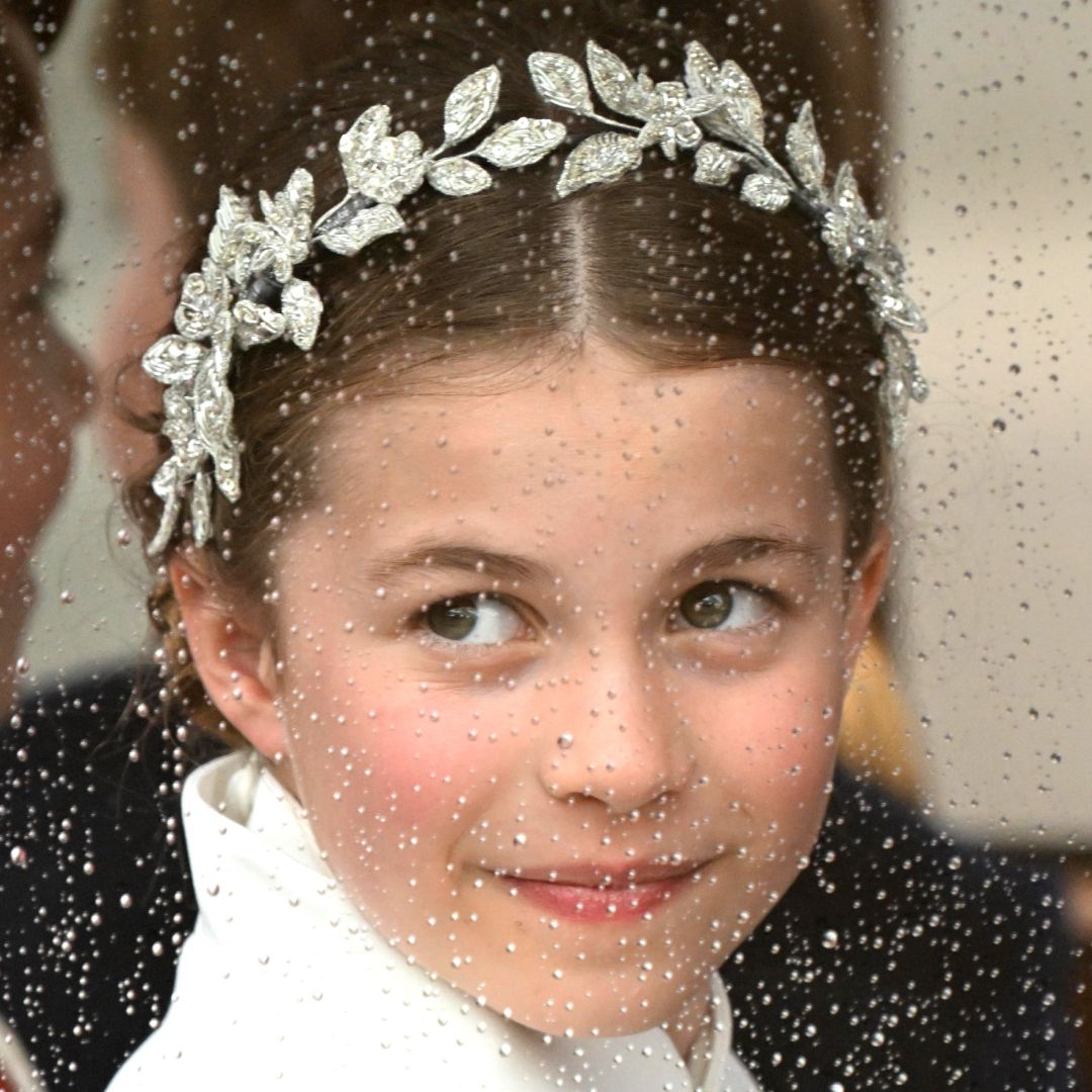 Princess Charlotte wearing a diamond wreath headpiece sitting in a rainy carriage