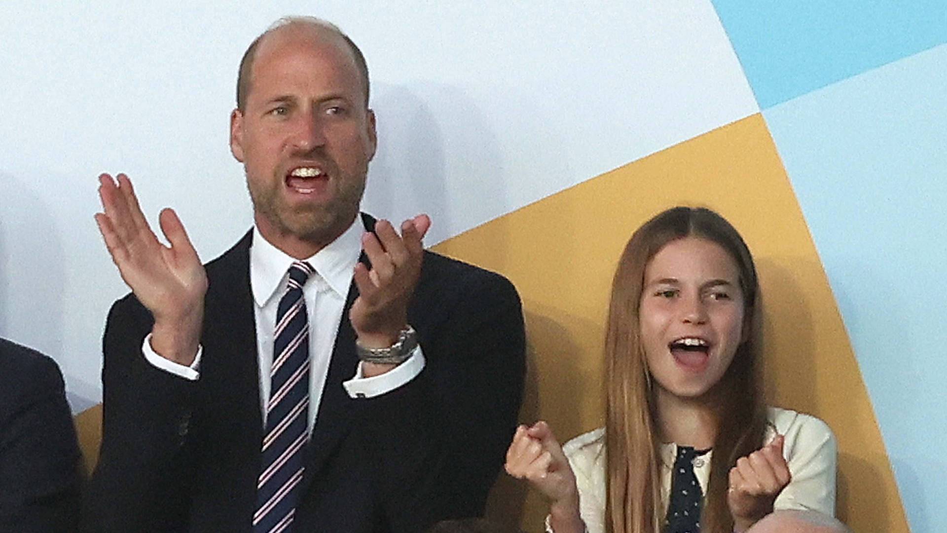 Prince William wears a suit with a red, white, and blue striped tie, and daughter Princess Charlotte wears a navy and white polka dot dress, as the pair attend the UEFA Women's Championship in Switzerland