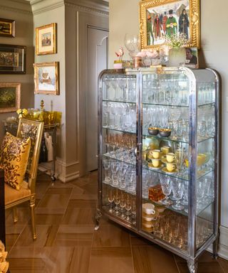 glass cocktail cabinet in dining room with taupe walls