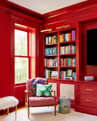 A corner in a living room, all painted red in satin finish